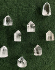 Eight quartz crystal towers are placed on a green surface. 