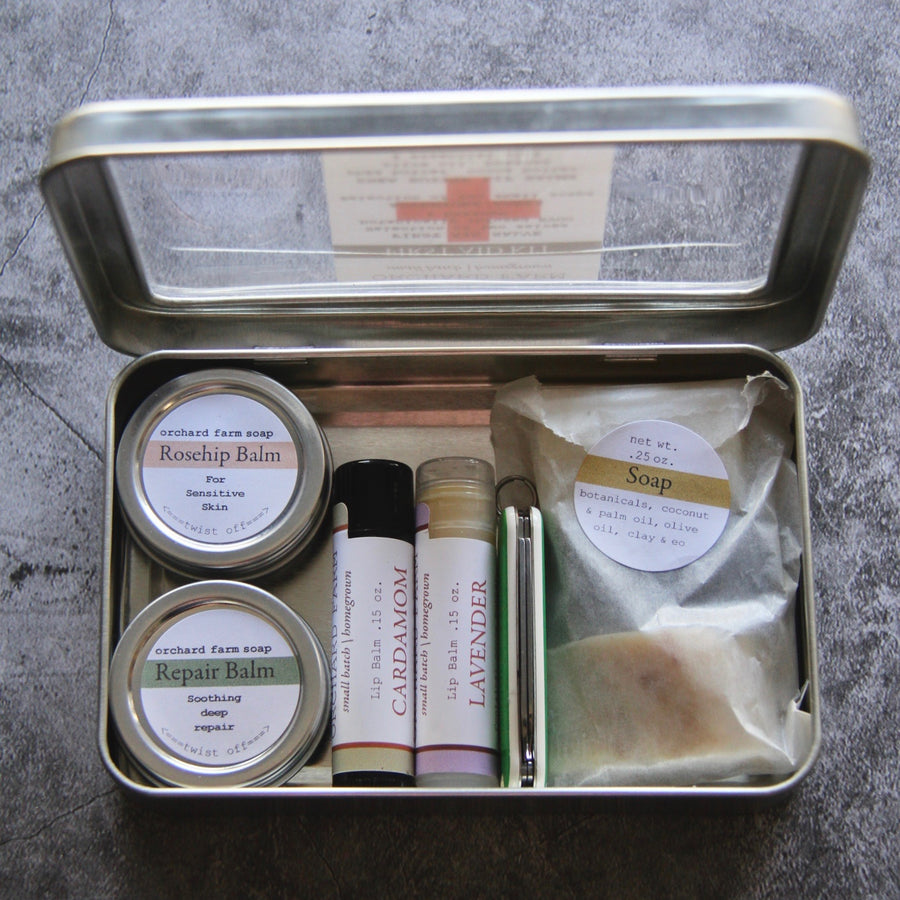 First Aid kit includes 2 small tins of salve, 2 lips balms, 3 small soaps and bandaids