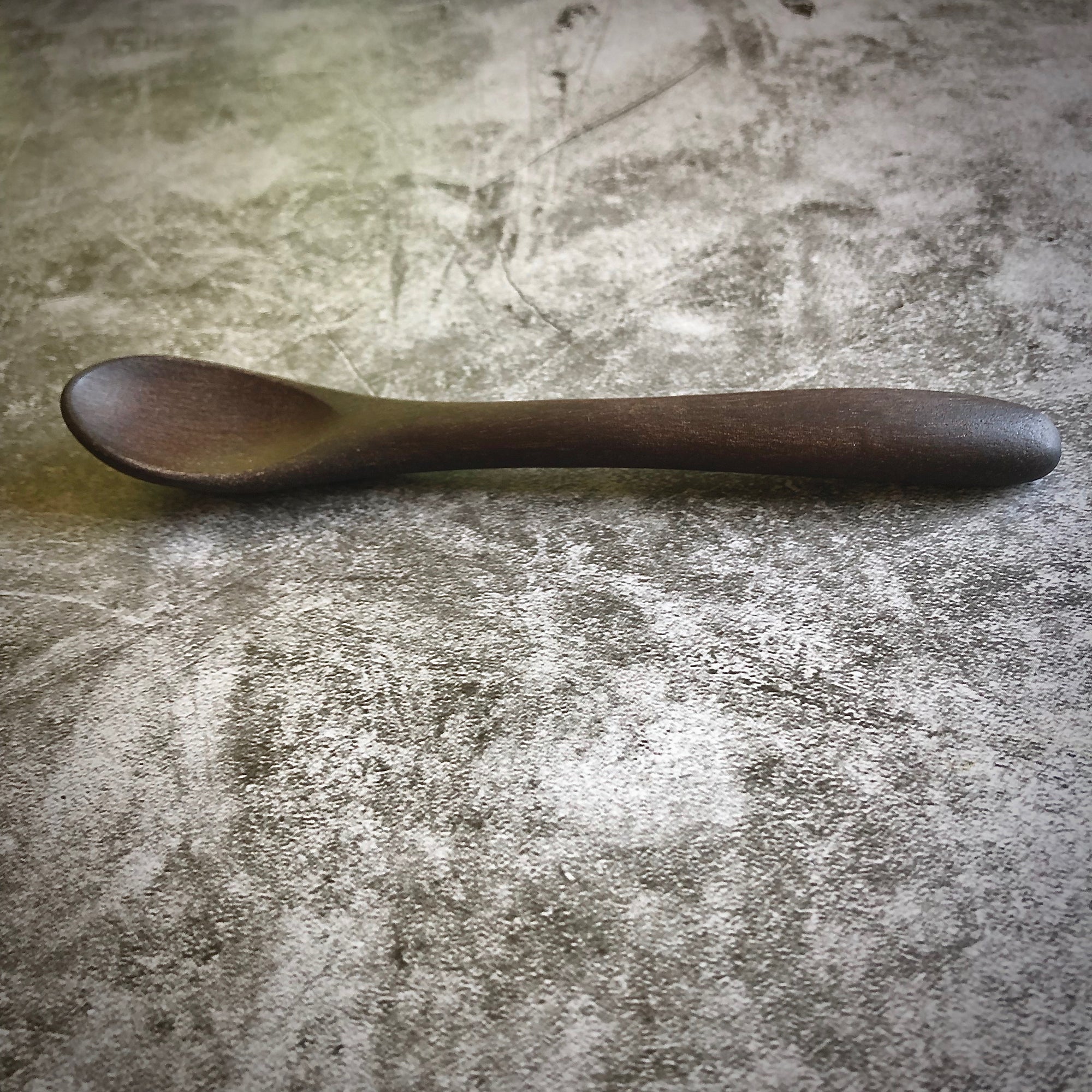 Small wooden spoon on gray background