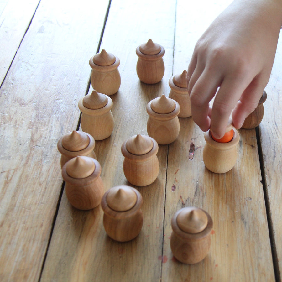 Child's hand playing with acorn memory game