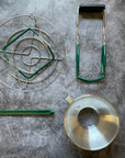 Contents of the Canning Gift Bundle displayed on a gray surface. Jar lifter, lid lifter, canning rack, and canning funnel. 