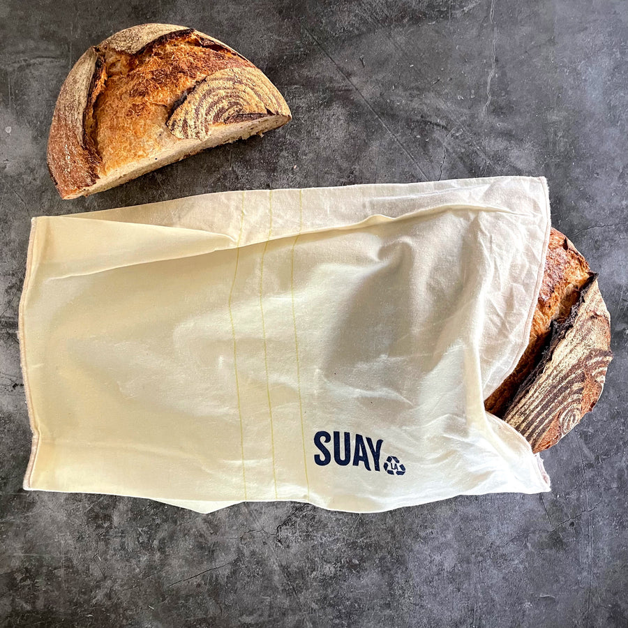 A loaf of bread peeks half way out of a wax-coated bread bag with the brand name 